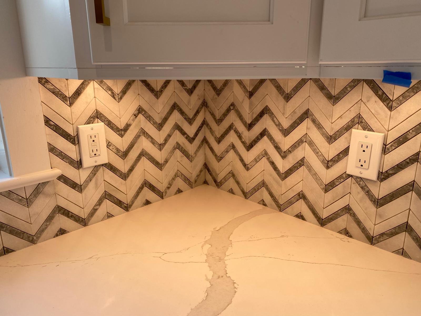 Detail of white and grey marble chevron mosaic backsplash