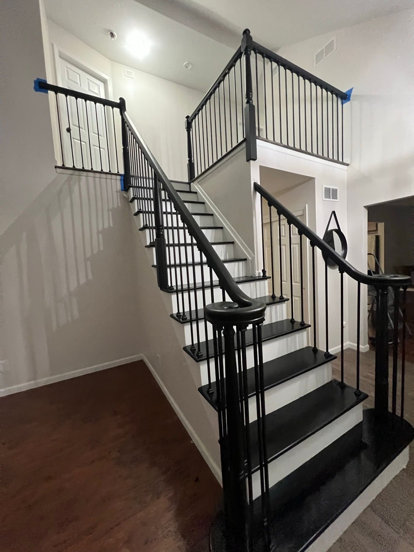 Refinished staircase painted black with iron balusters