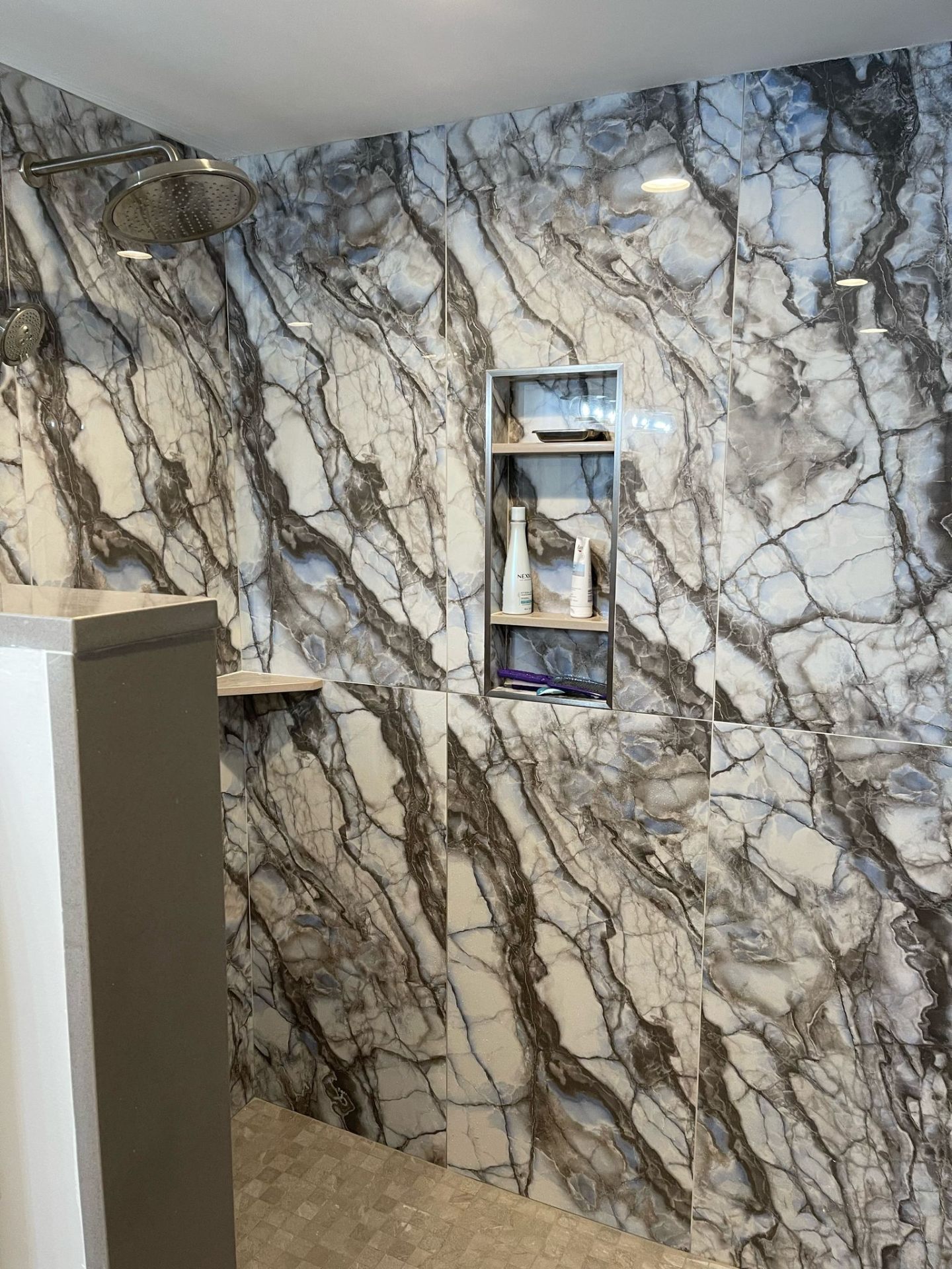 Luxury shower with dramatic blue and grey marble-look tile