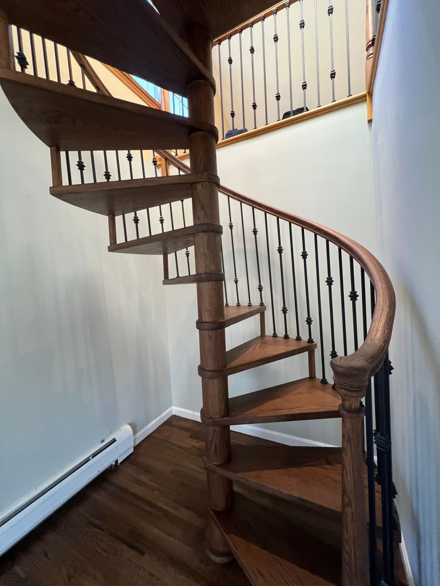 Custom oak spiral staircase with iron balusters