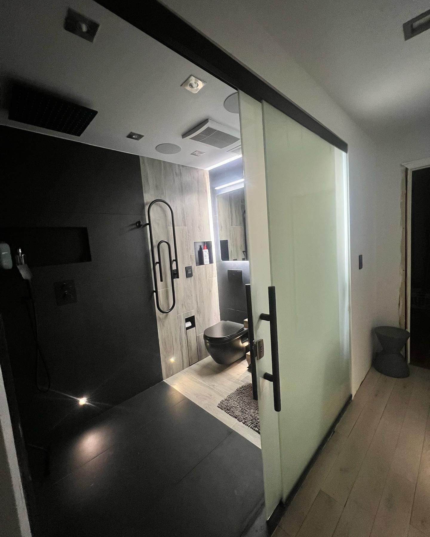 Modern bathroom entry with frosted glass sliding door and tile design