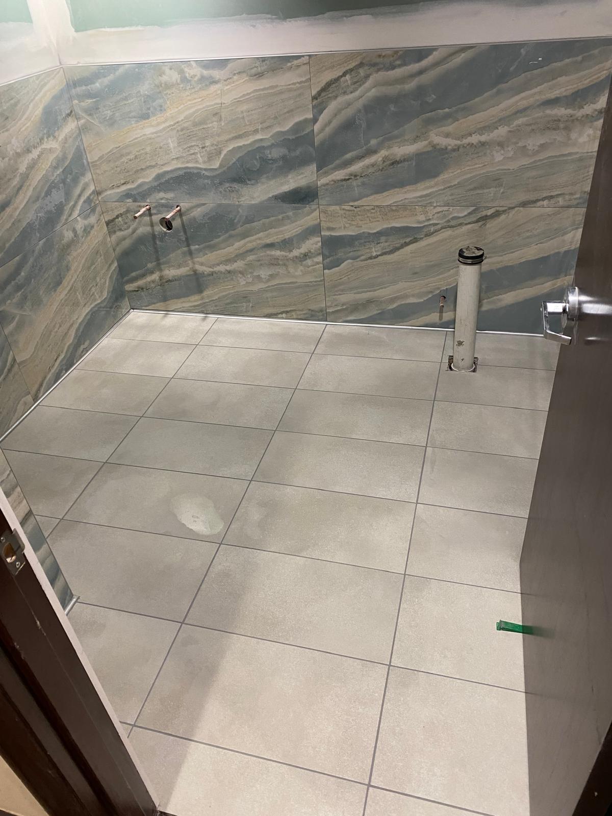 Bathroom with dramatic blue onyx tile walls and grey floor tile