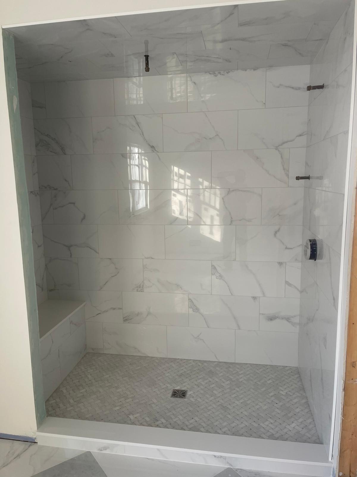 Marble subway tile shower with basketweave mosaic floor