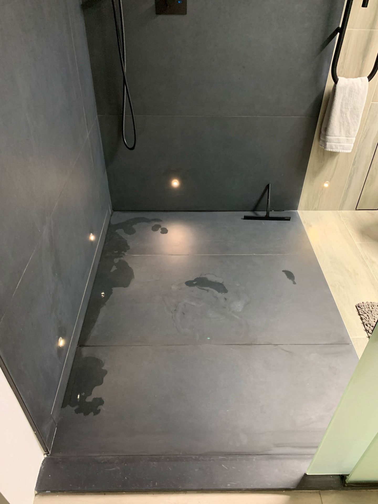 Wet shower floor in matte black large-format porcelain tile