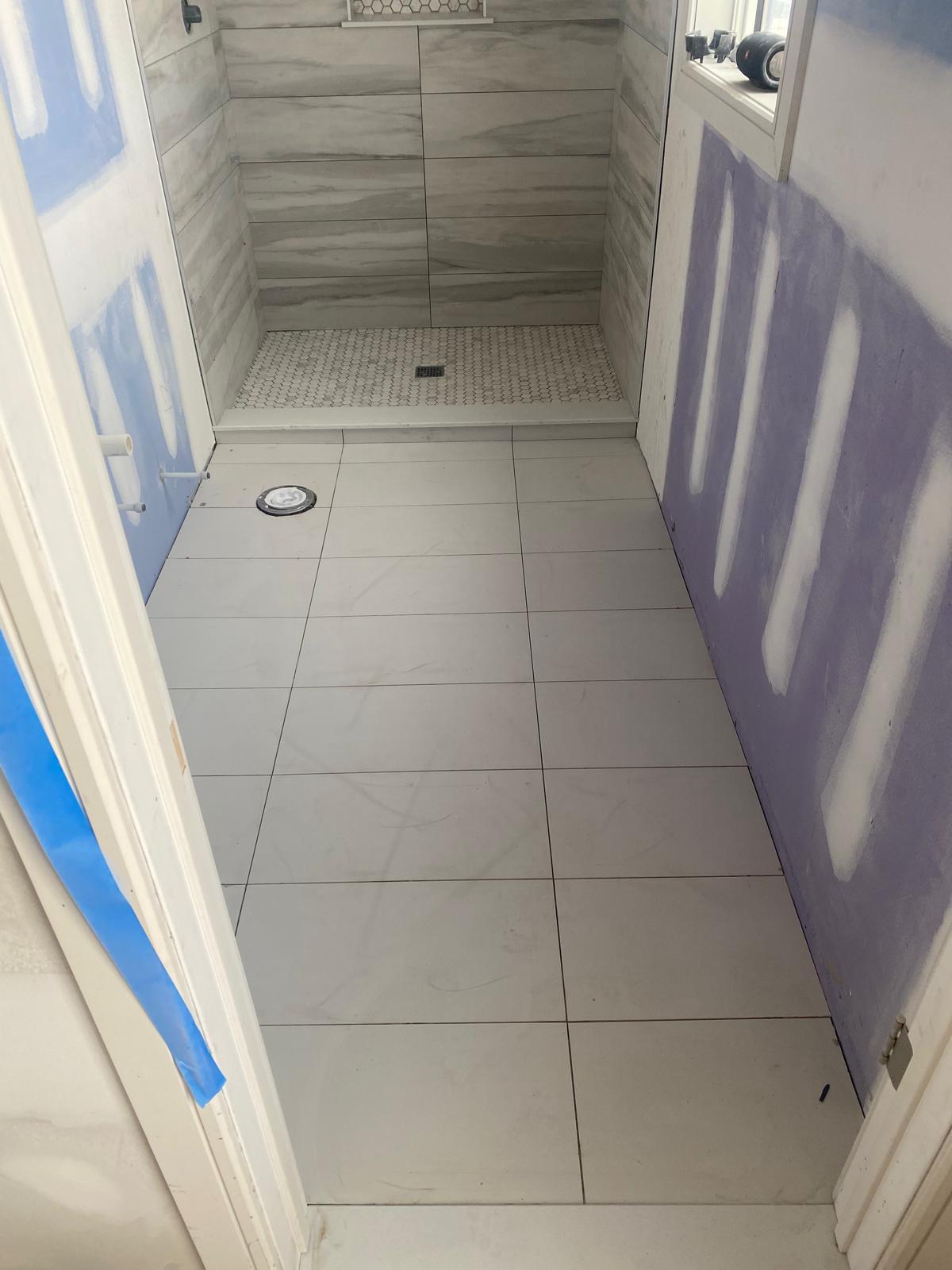 White marble-look tile bathroom floor with matching shower walls